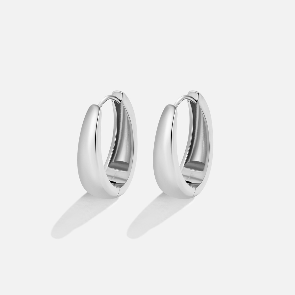 Valentina Silver Hoop Earrings, a pair of polished silver oval hoops on a plain light background