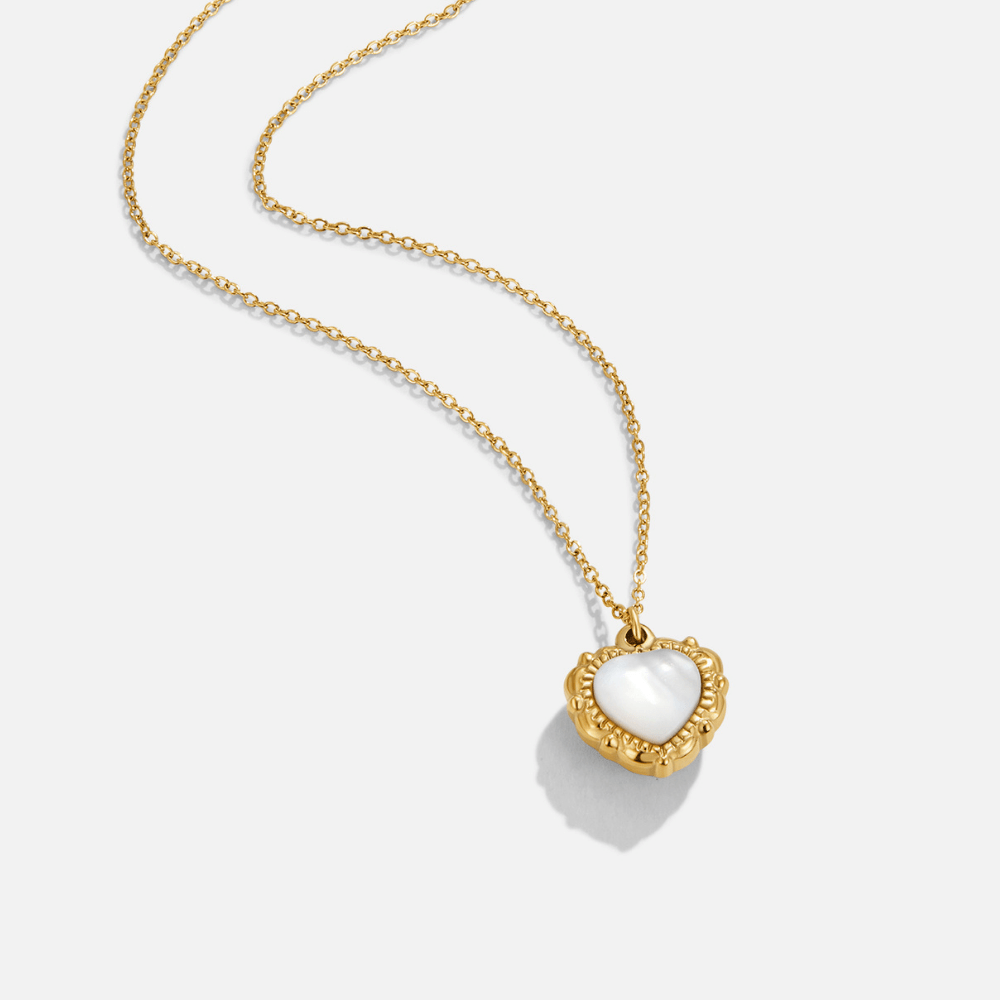 Vintage Eternity Love Necklace, gold chain necklace with a white heart pendant on grey background