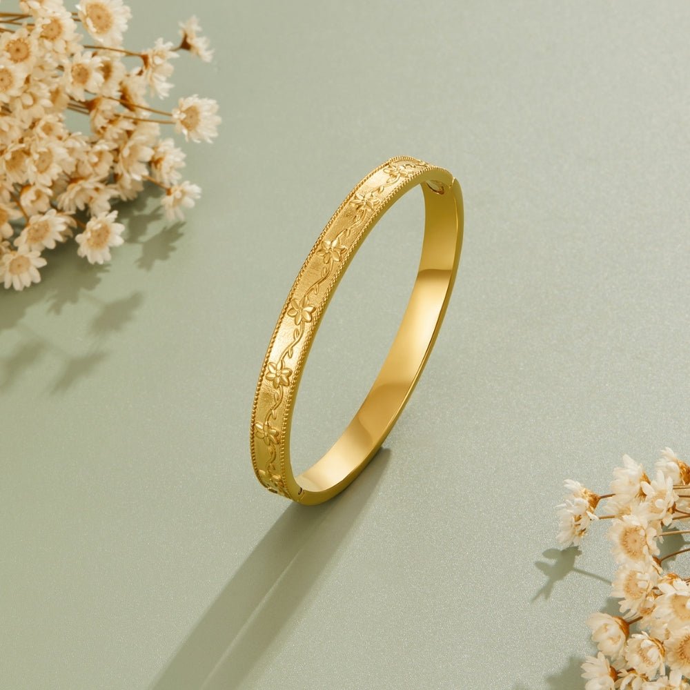 Vintage Gold Vine Bangle, standing upright on sage green, with dried white flowers around it