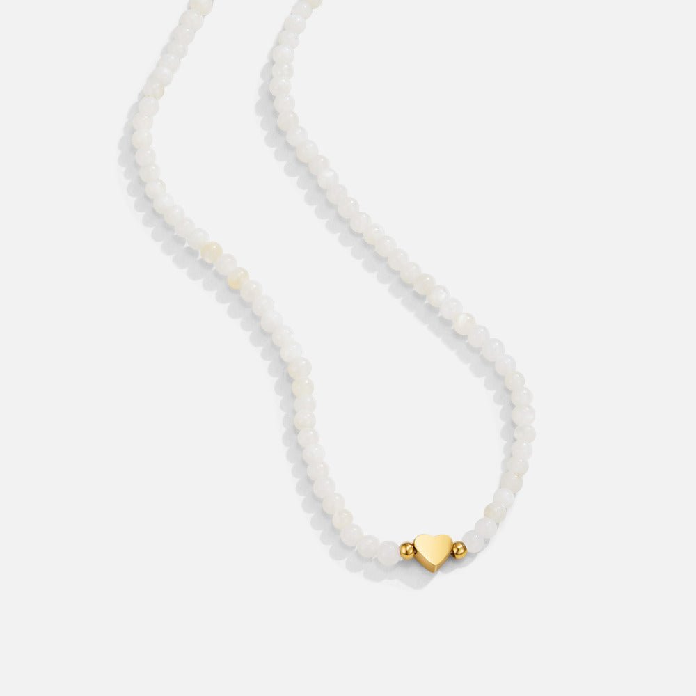 White Selene Bead Necklace, laid flat on white, small pearly beads with a gold heart charm