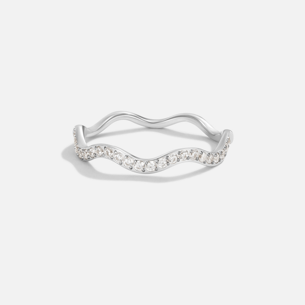 Zenya Crystal & Silver Wave Ring, ring lying flat on a plain light background, wavy band with