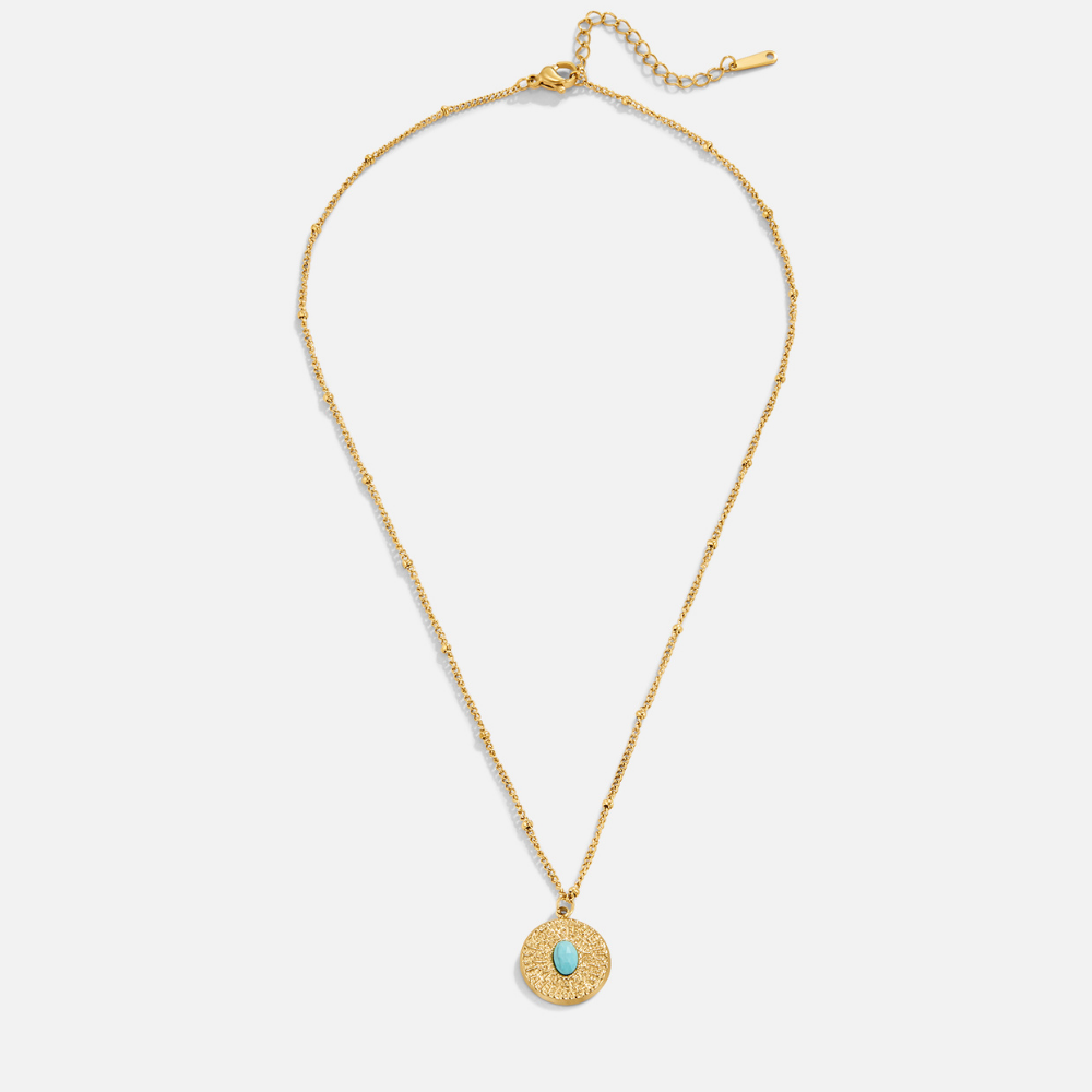 Turquoise Stone Coin Necklace, flat lay of gold chain with round textured pendant and oval