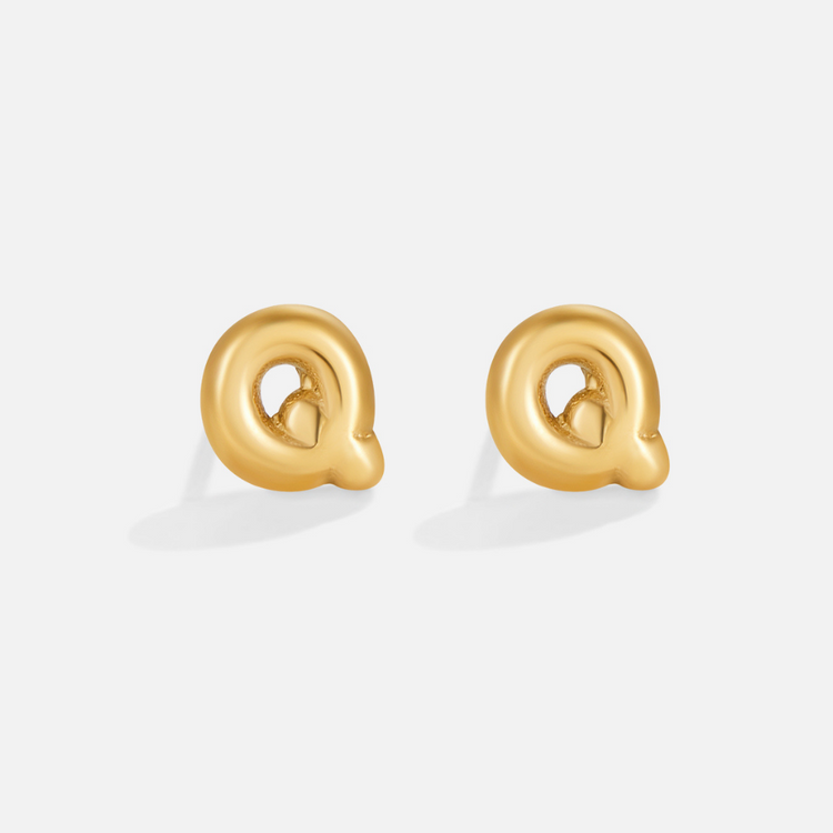 Gold Bubble Letter Earrings, a pair of shiny gold stud earrings shaped like the letter Q