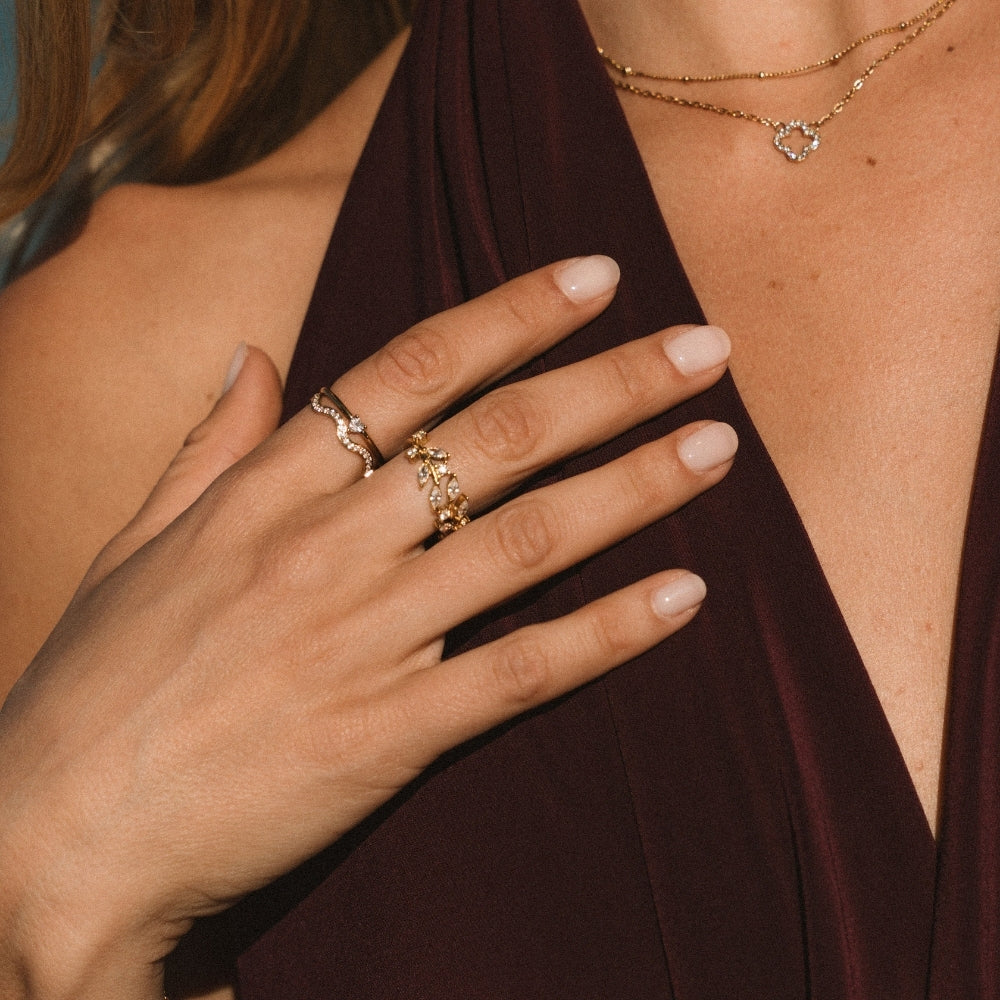 Zenya Crystal & Gold Wave Ring, worn on a hand with a stacked gold ring and a necklace