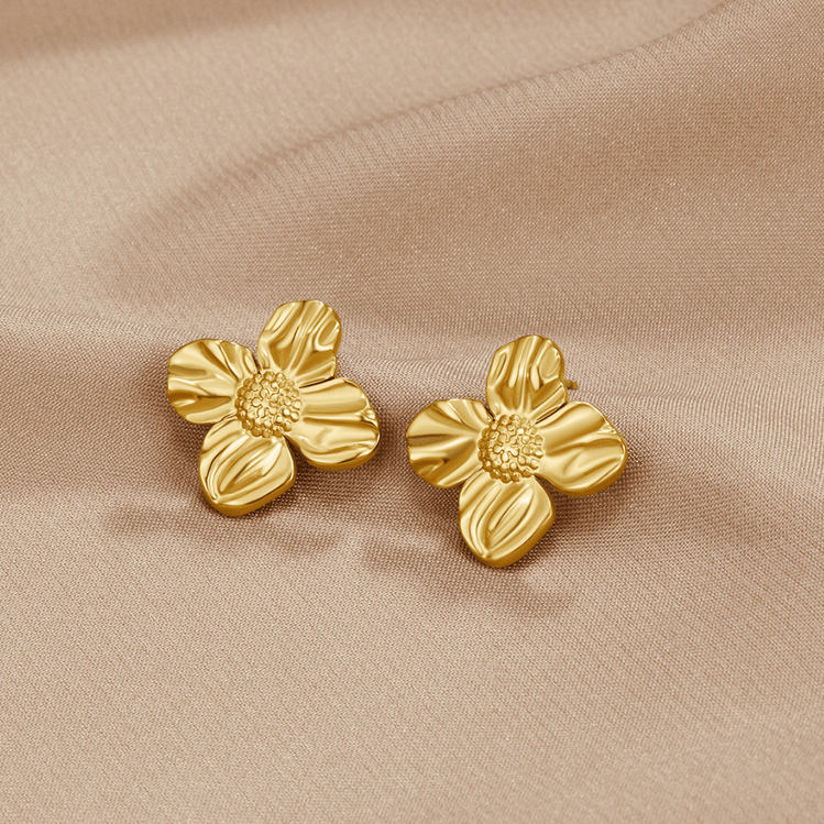 18K Gold Flower Earrings, a pair of four-petal gold earrings lying on beige satin fabric