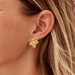 18K Gold Flower Earrings, worn on an ear, gold four-petal flower stud with textured centre