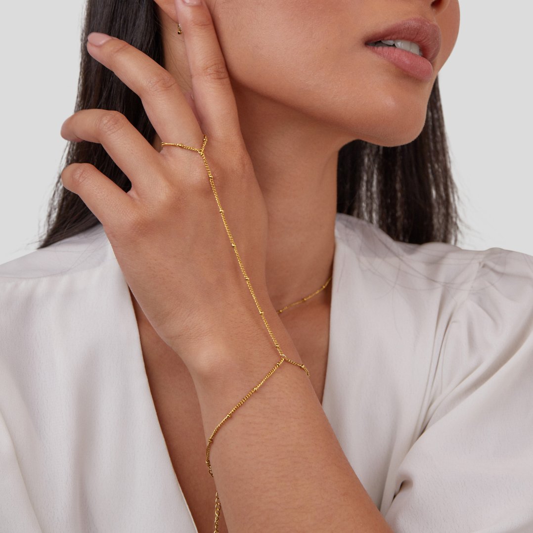 Free 18K Gold Hand Chain Bracelet, worn on a hand with a thin gold chain across the fingers
