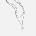 Angela Pearl Silver Necklace, layered silver chains on white, with a pearl pendant at the lower end