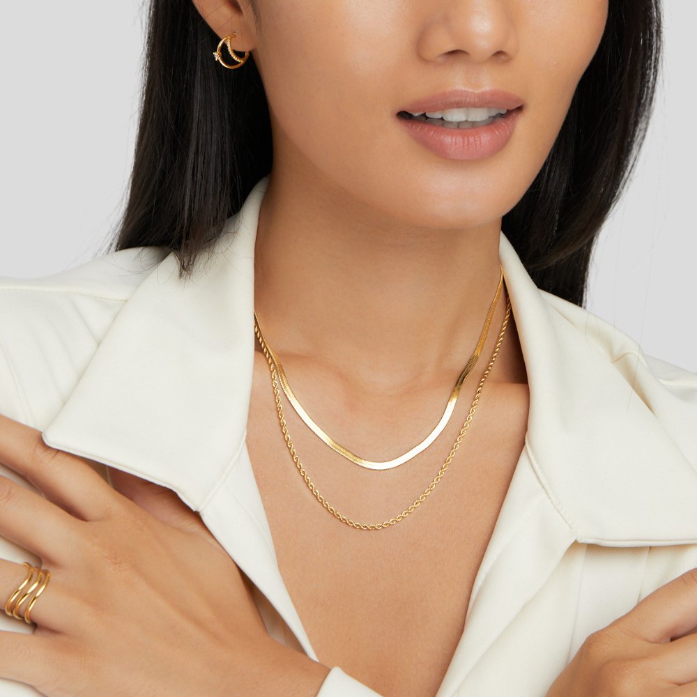 Alexandra Layered Necklace, worn on a model in a white jacket, with a crescent earring