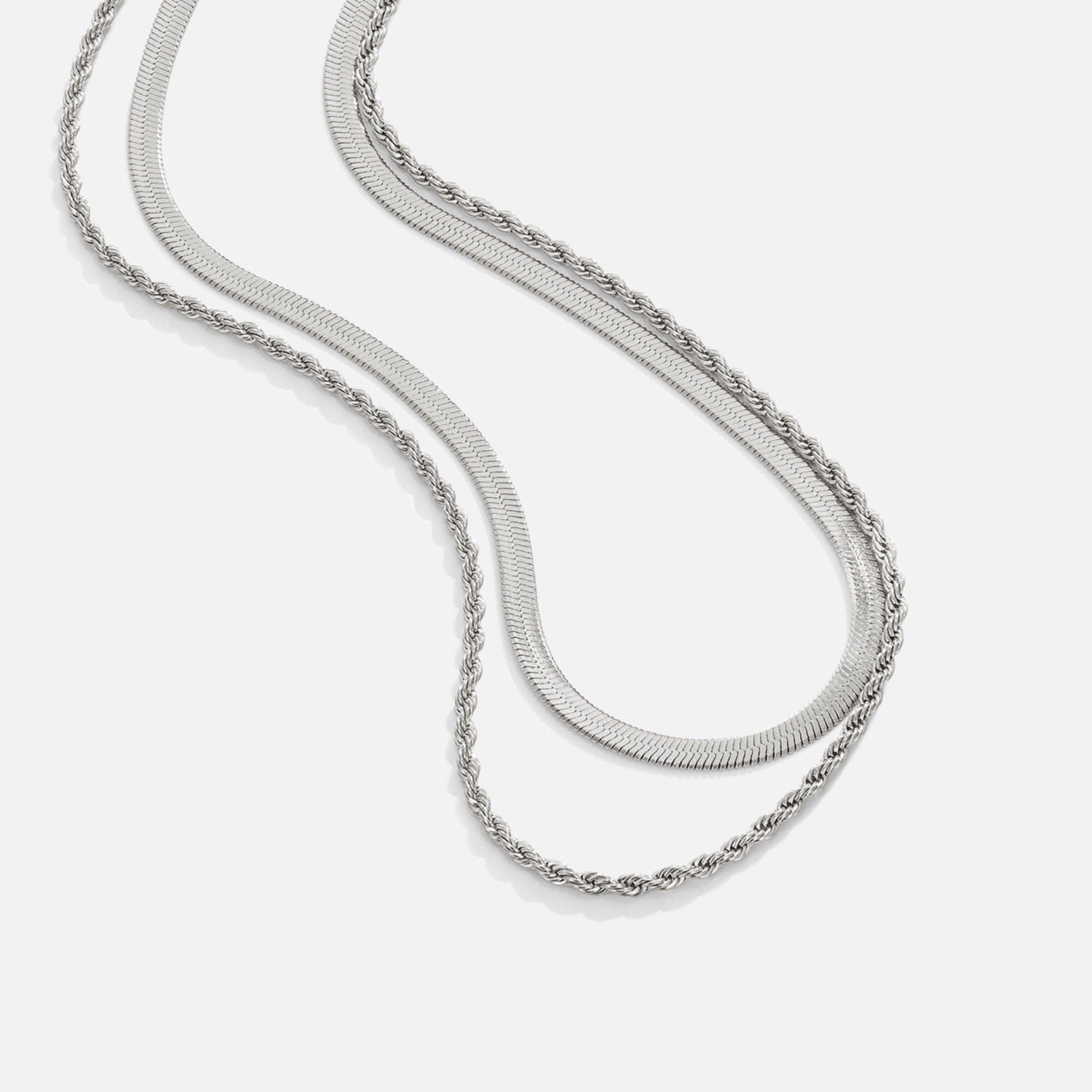 Alexandra Silver Layered Necklace, two silver chains laid out in a flowing curve on white
