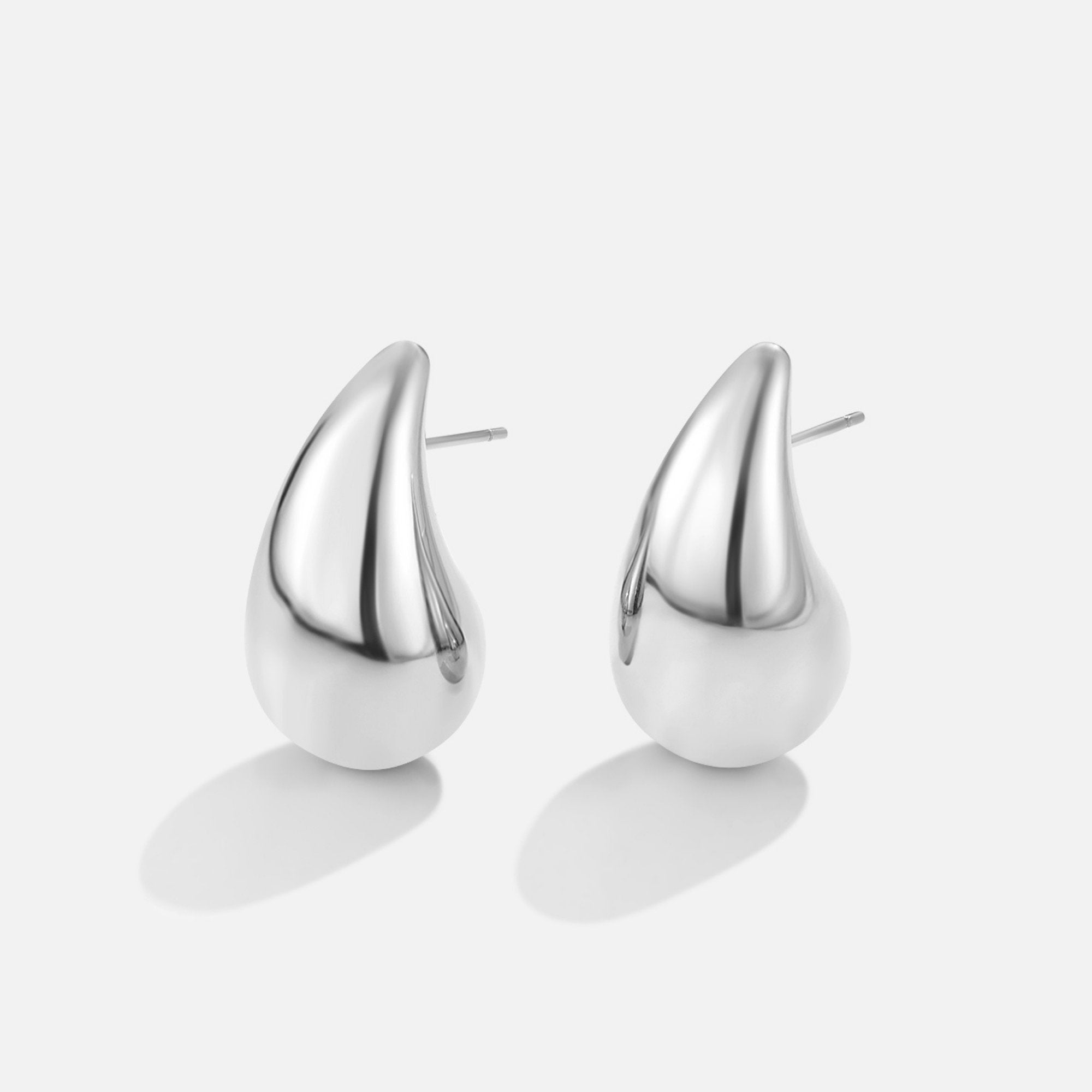 Amara Teardrop Silver Earrings, pair of polished silver teardrop earrings on a plain white
