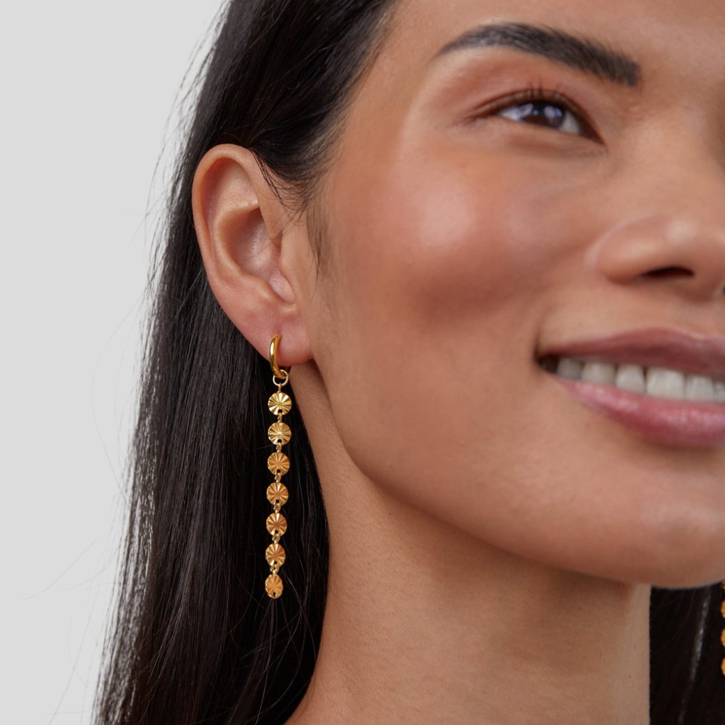 Amari 18K Gold Disc Earrings, worn on an ear, long gold disc drop with radiating lines