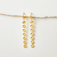 Amari 18K Gold Disc Earrings, pair hanging against white paper, gold discs in a row
