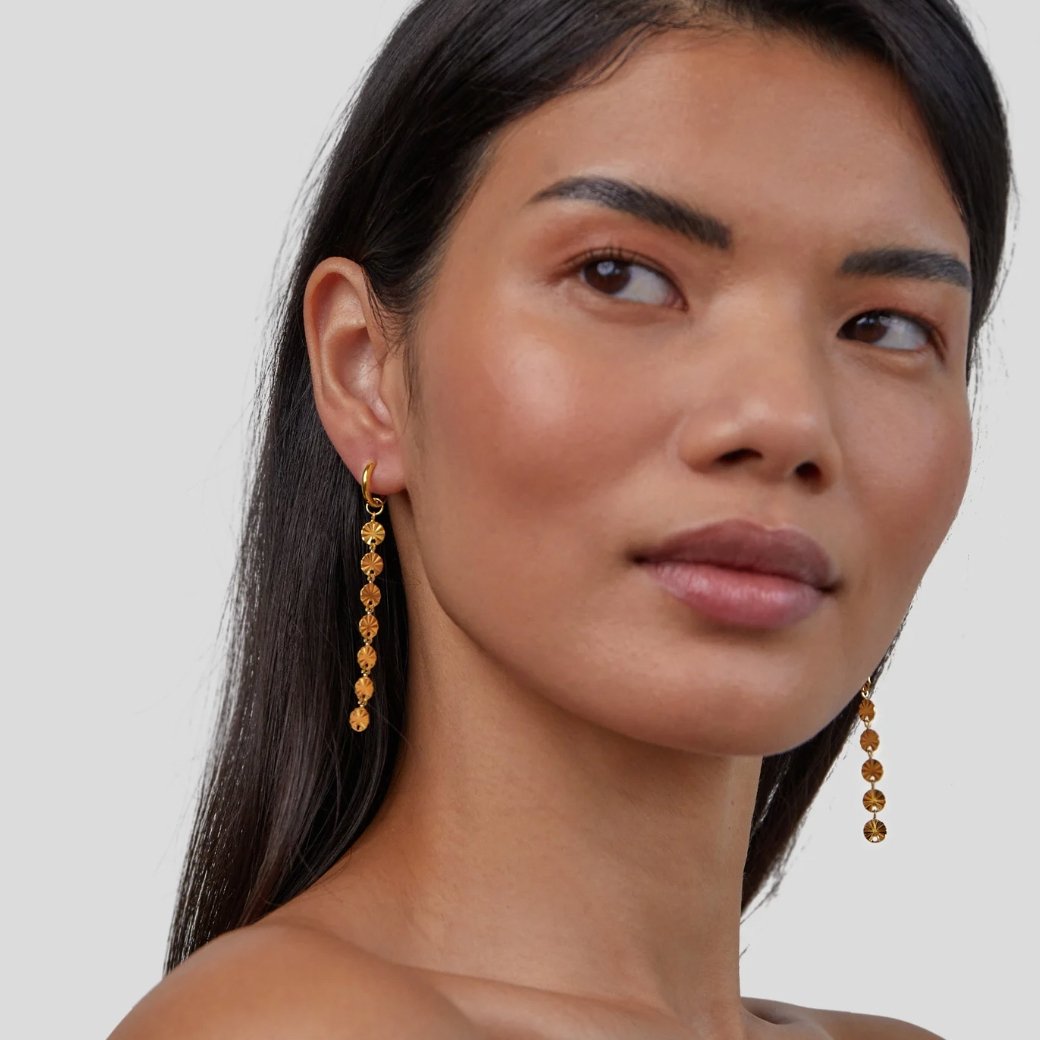 Amari 18K Gold Disc Earrings, worn by a model with long dark hair, gold disc drop earrings