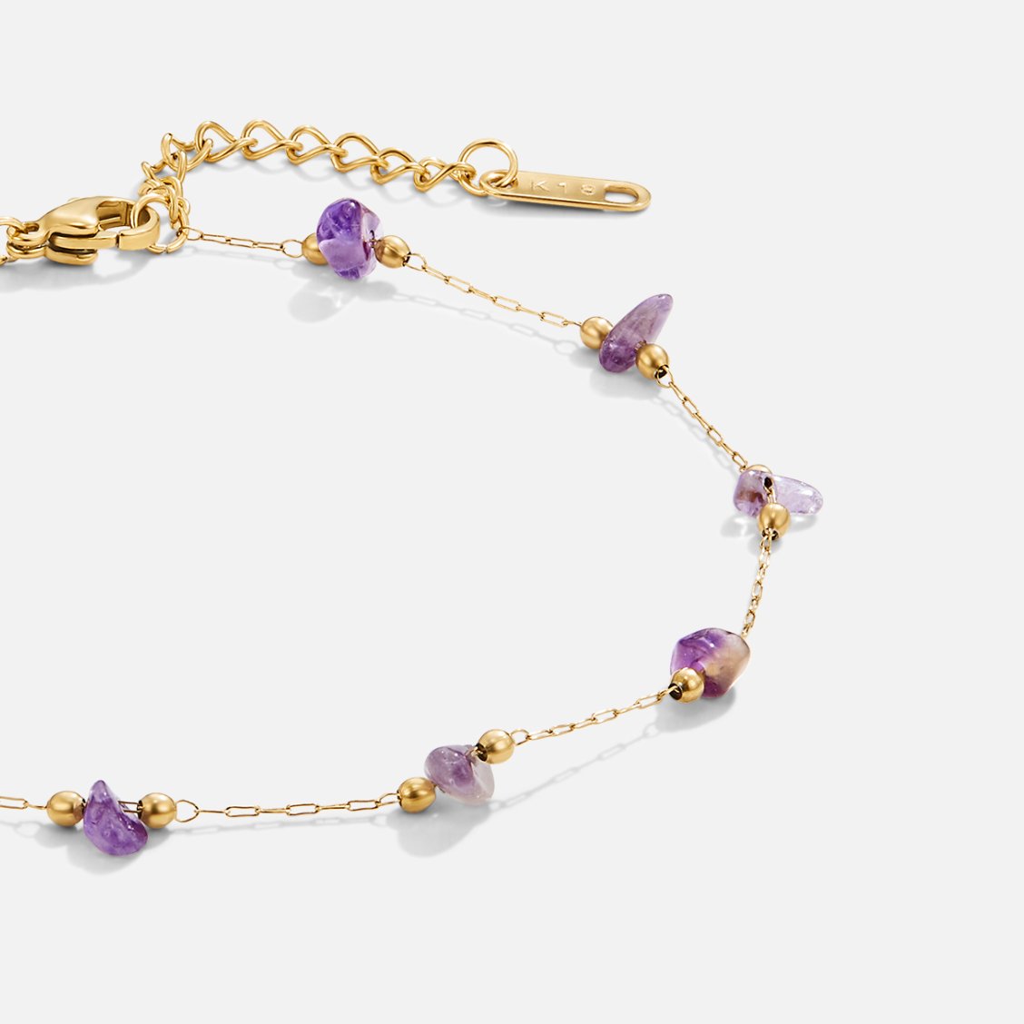 Amethyst Stone Anklet, flat on a light background, gold chain with purple amethyst nuggets