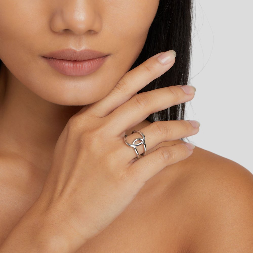 Astrid Silver Ring, worn on a hand touching a cheek, silver woven band visible