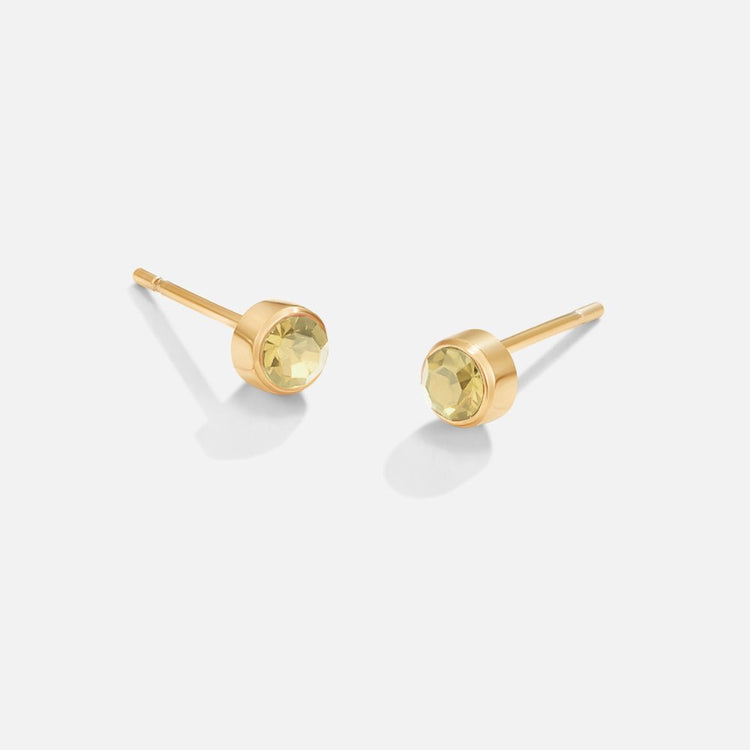 Birthstone Stud Earrings, pair of gold stud earrings with pale yellow-green stones on white