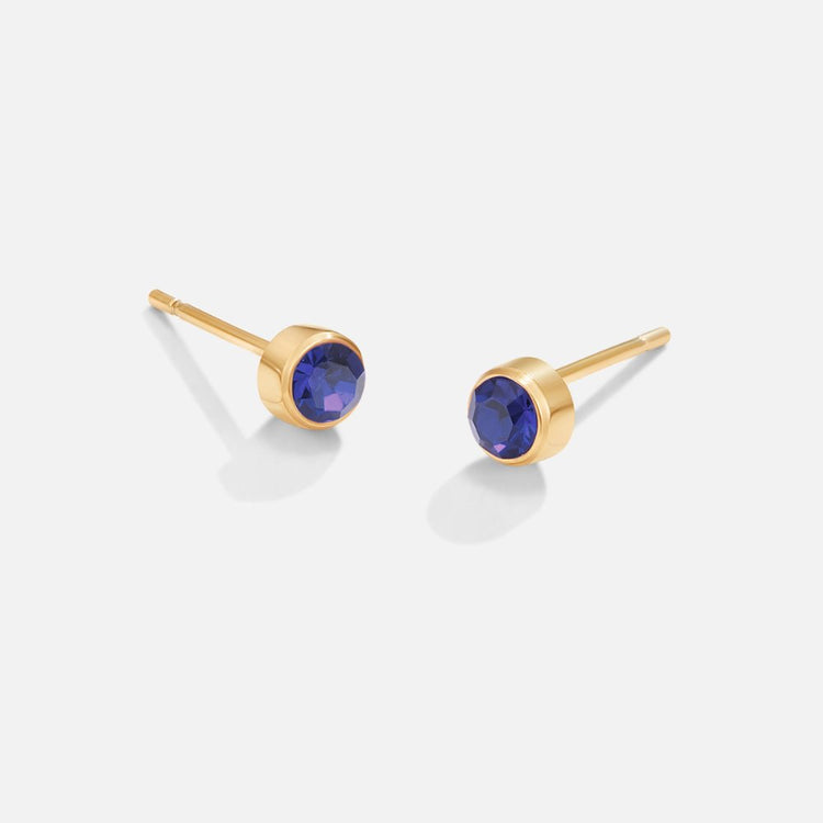 Birthstone Stud Earrings, pair of gold studs with round blue gemstones, on white