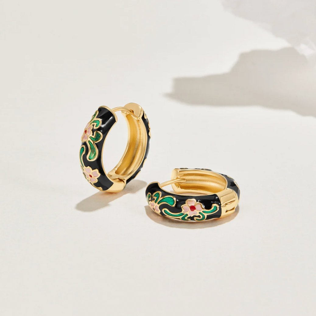 Black Gold Hoop Flower Earrings, a pair of hoops standing on a pale surface, black enamel with