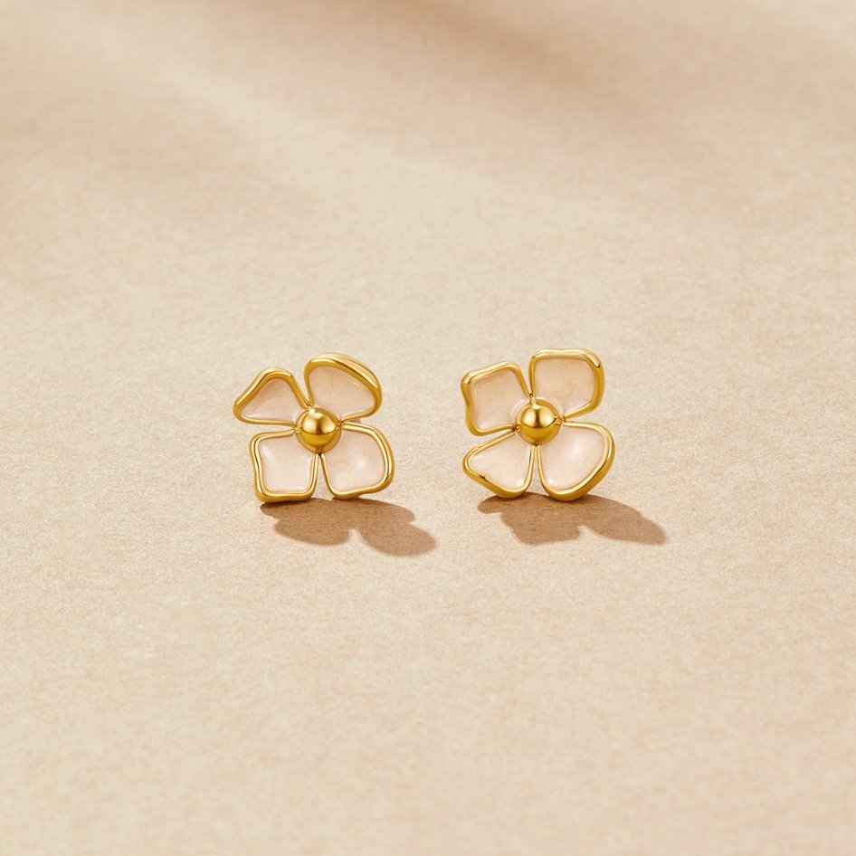 Blooming Blossom Earrings, pair of four-petal studs on a beige surface, gold with cream petals