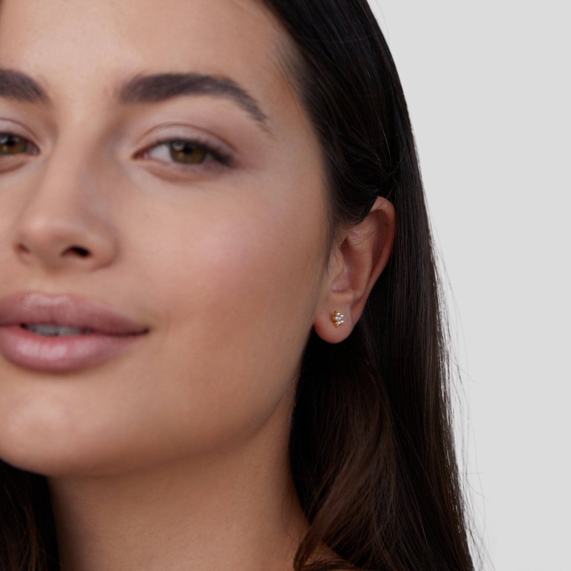 Blooming Flower Pearl Earrings, worn in an ear on a model with long dark hair