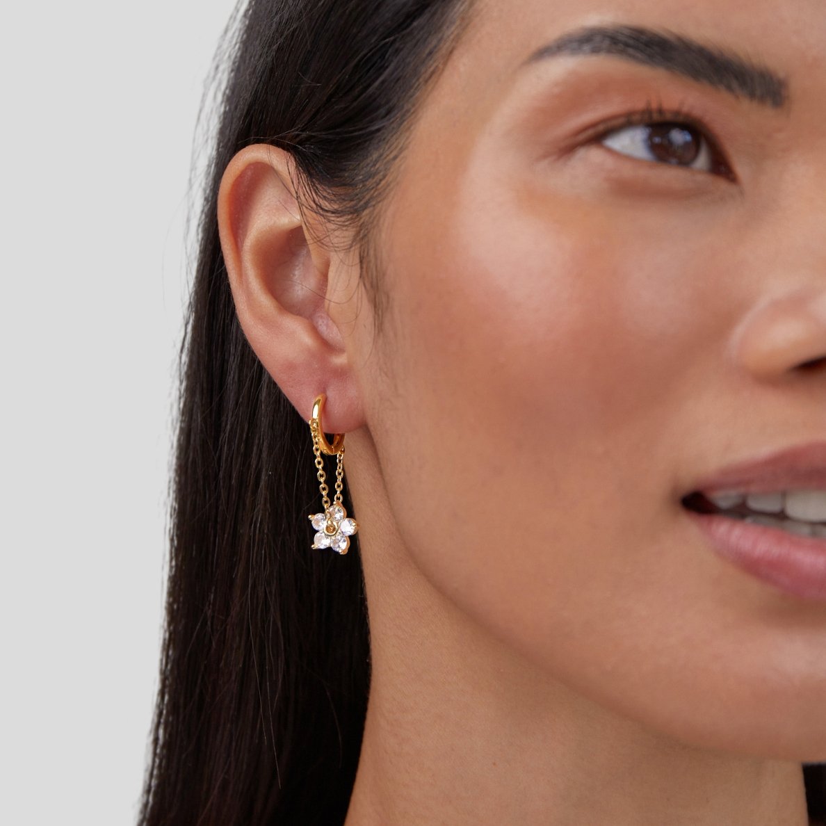 Blooming Petal Crystal Earrings, worn on an ear, gold hoop with a crystal flower charm