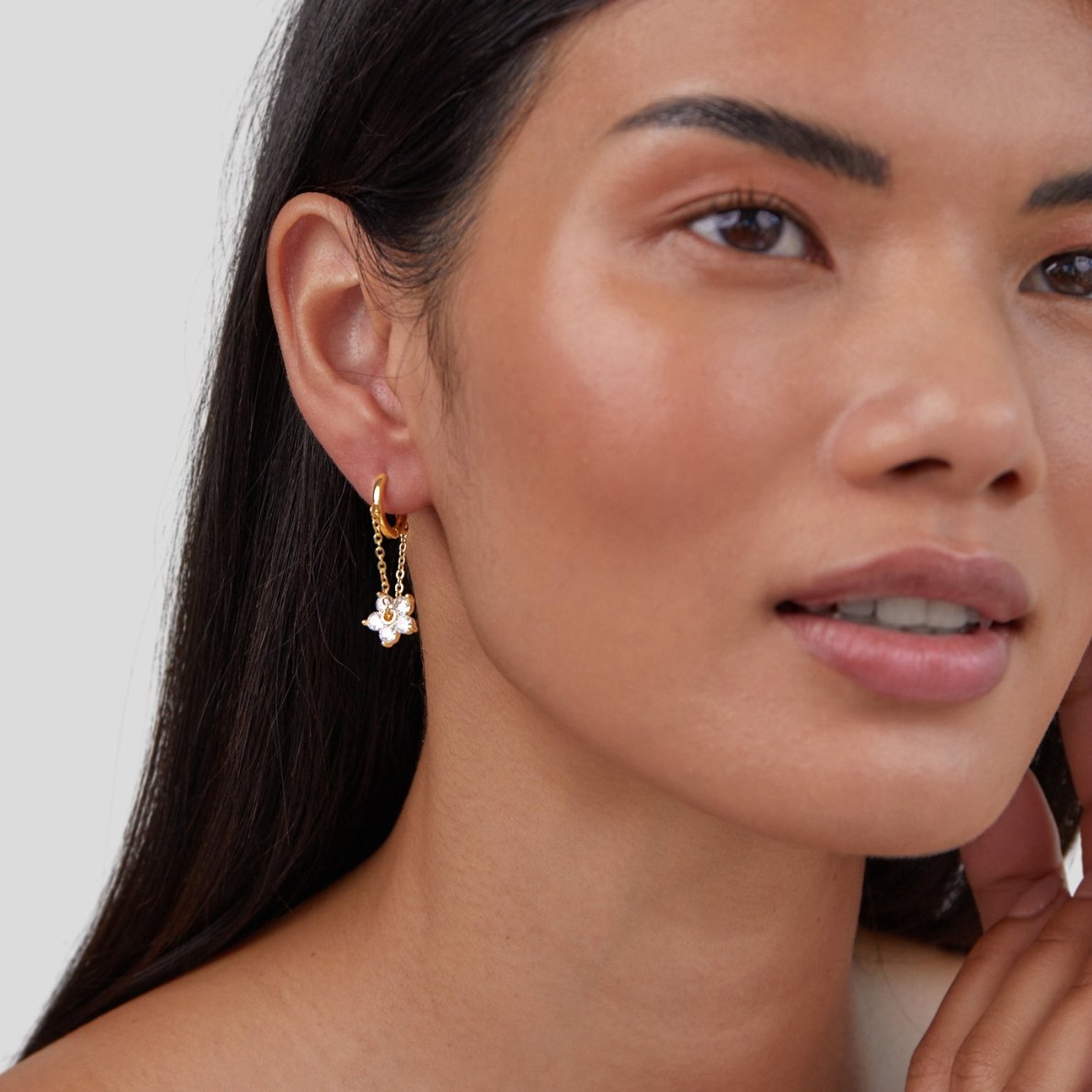 Blooming Petal Crystal Earrings, worn on an ear, gold hoop with a crystal flower charm