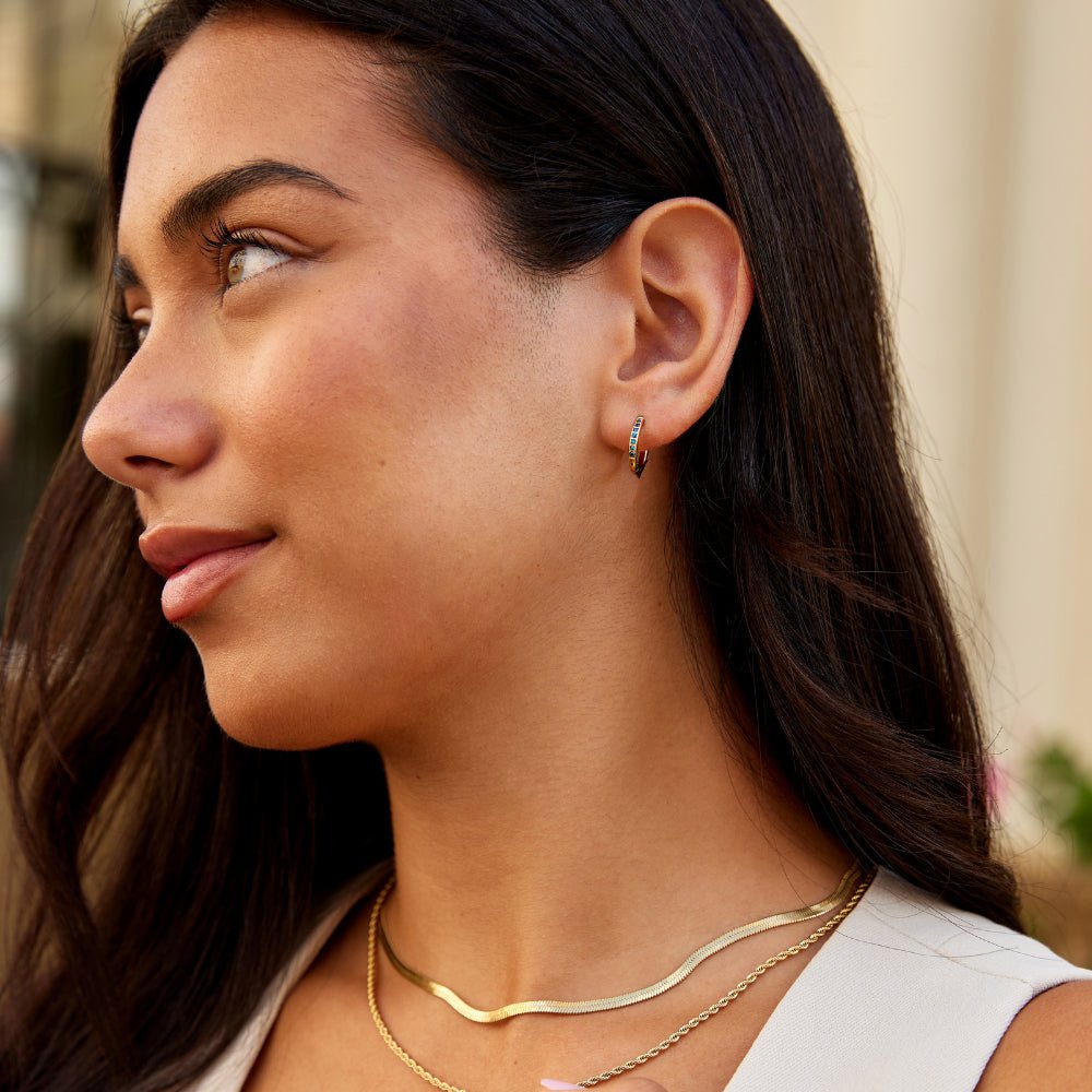 Blue Eternity Hoop Earrings, worn on an ear with gold layered necklaces, side profile