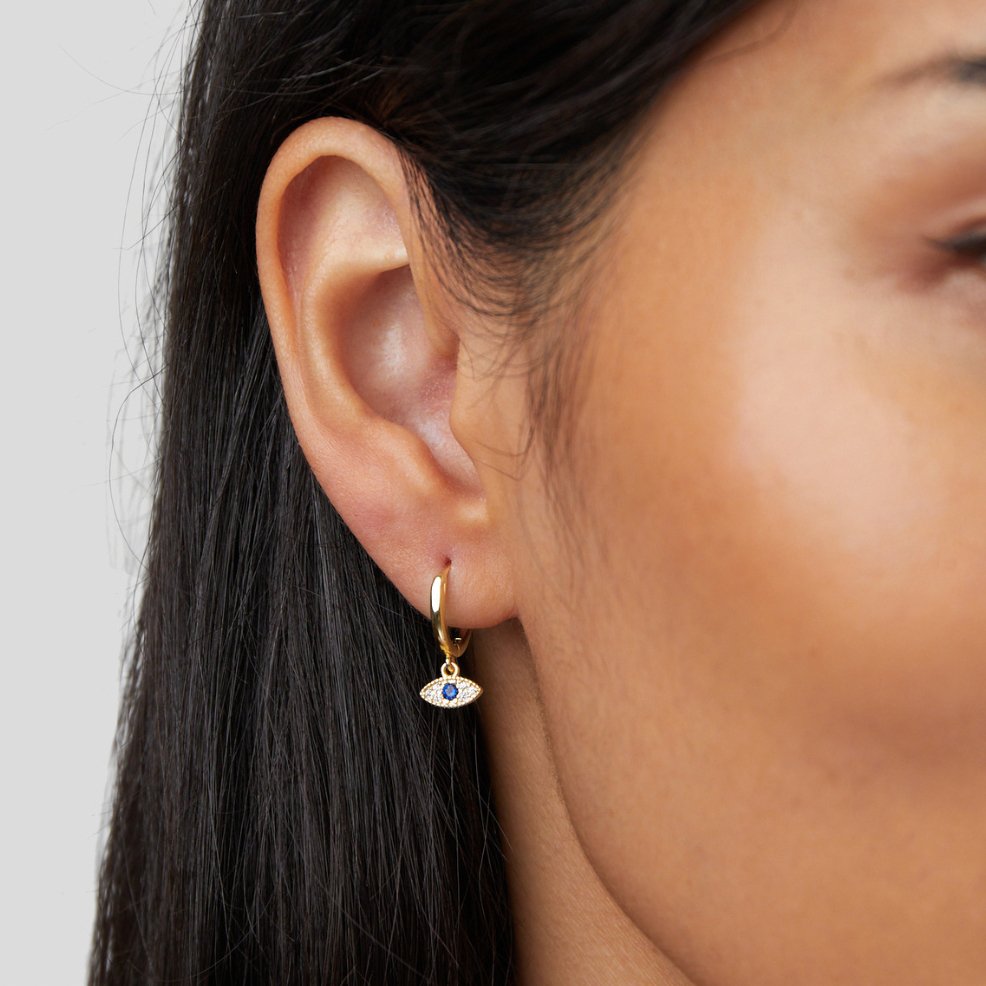 Blue Evil Eye Drop Earrings, worn on an ear, gold hoop with blue evil eye charm