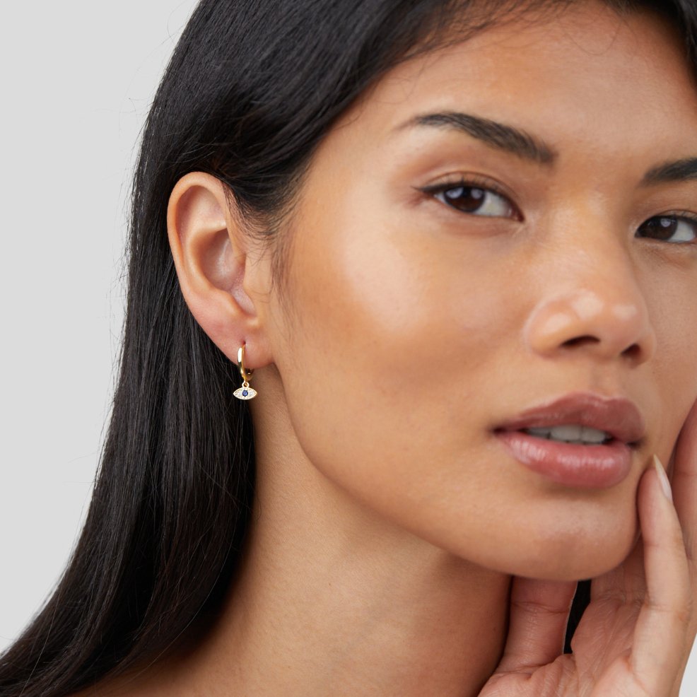 Blue Evil Eye Drop Earrings, worn in one ear on a model with long dark hair