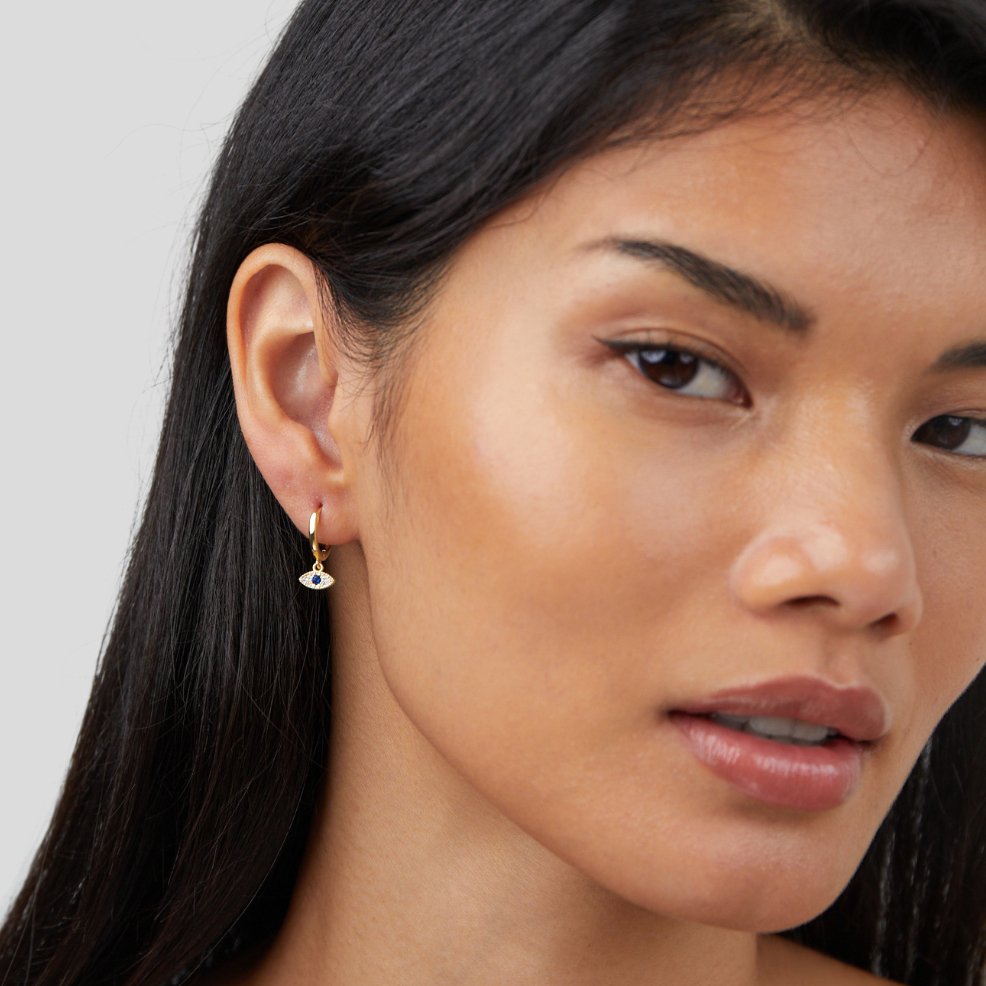 Blue Evil Eye Drop Earrings, worn in one ear by a model with long dark hair