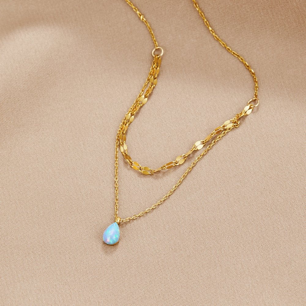 Blue Opal Teardrop Layered Necklace, two gold chains on beige satin, teardrop opal pendant