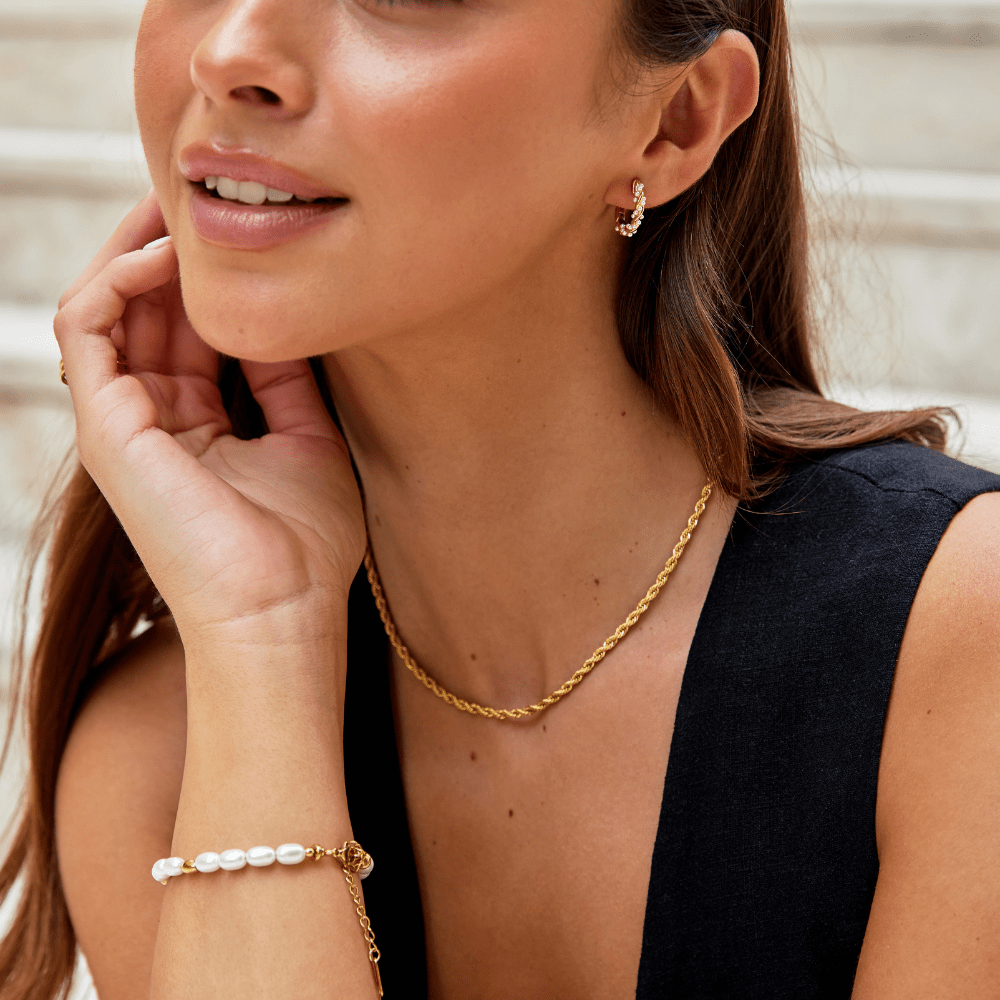 Free Calla Gold Twisted Chain Necklace, worn on a woman with a pearl bracelet and gold hoop