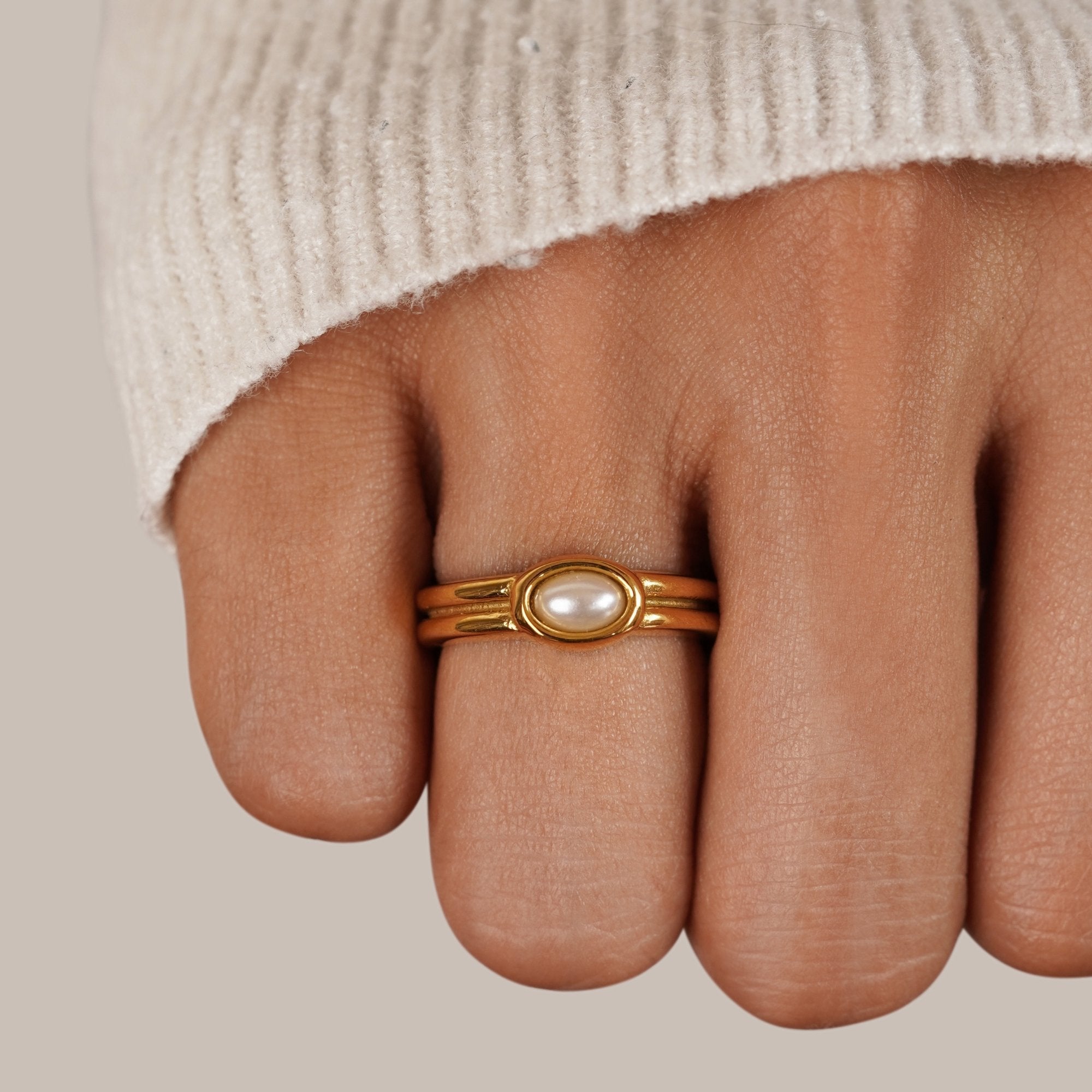 Chunky Pearl 18K Gold Ring, worn on a hand in a cream knit sleeve, gold band with pearl