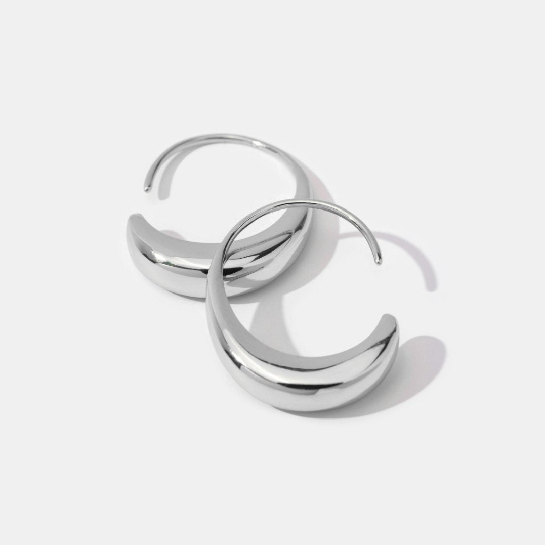 Classic Silver Drop Hoop Earrings, pair of polished silver hoop earrings lying flat on white