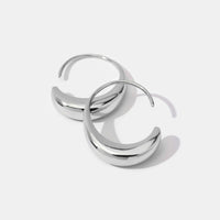 Classic Silver Drop Hoop Earrings, pair of polished silver hoop earrings lying flat on white