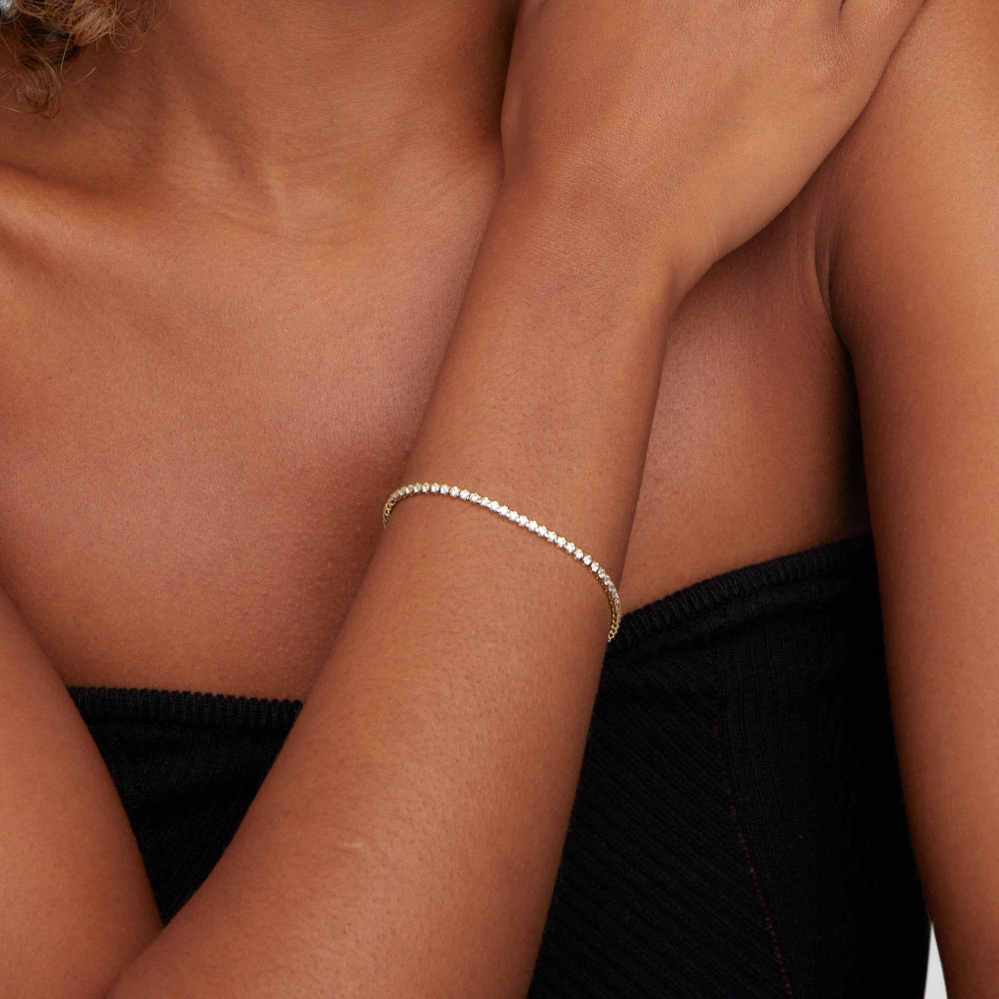 Cordelia Silver Tennis Bracelet, worn on a wrist with a hand resting on shoulder, black top