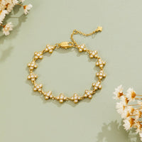 Crystal Blossom Clustered Bracelet, laid flat on sage green with dried white flowers around it