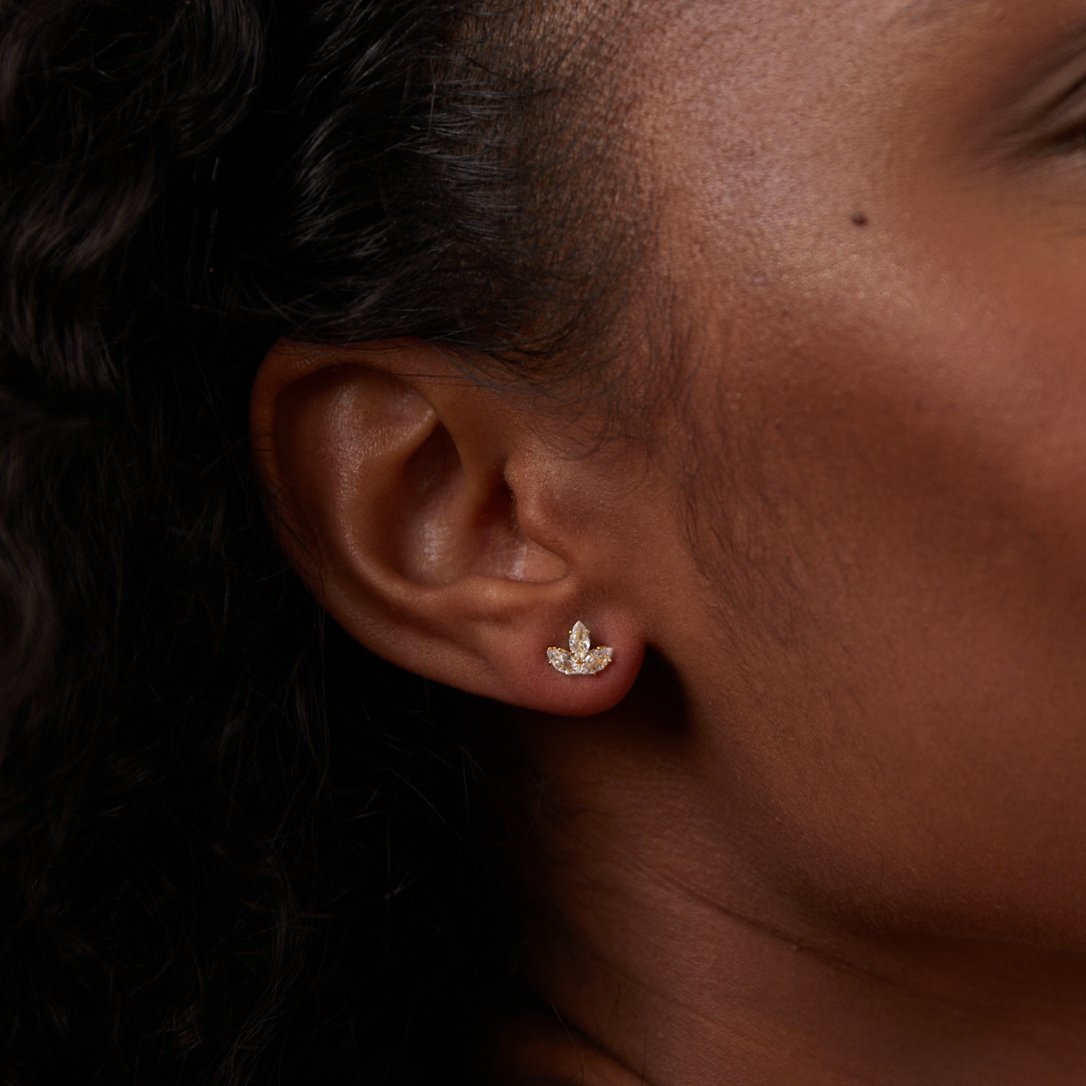 Crystal Lotus Waterfall Earrings, worn on an ear with curly dark hair, close-up profile view