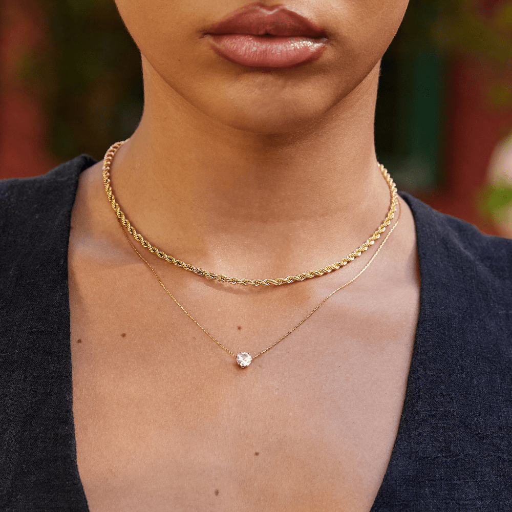 Dainty Round Crystal Necklace, worn on a neck layered over a thick gold rope chain