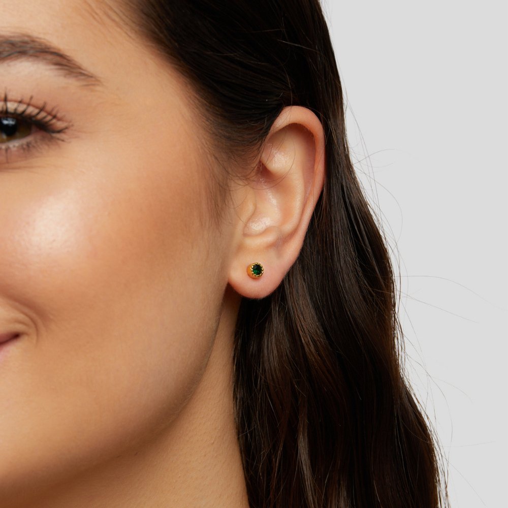 Emerald Green Stud Earrings, worn on an ear, close-up of a round green stone in gold