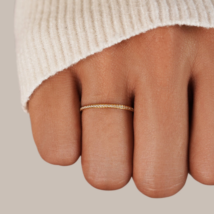 Eternity 18K Crystal Ring, worn on a finger below a cream knit sleeve, close-up