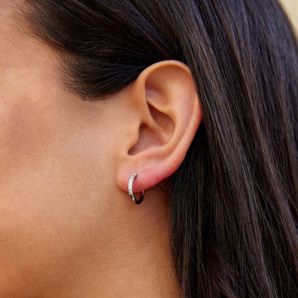 Eternity Hoop Earrings, worn on an ear with dark hair behind, close-up of a small hoop