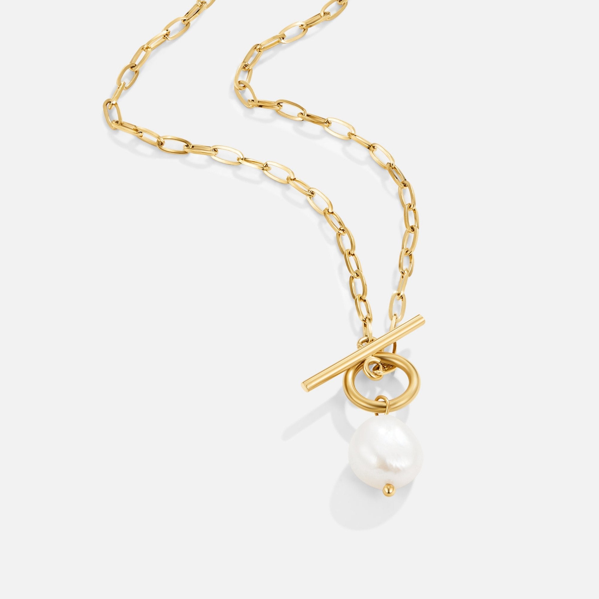 Eva Freshwater Pearl Gold Necklace, gold chain necklace laid flat on pale grey, pearl pendant