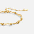 Figaro Gold Knot Chain Bracelet, close-up of a gold twisted-link chain with extender and tag