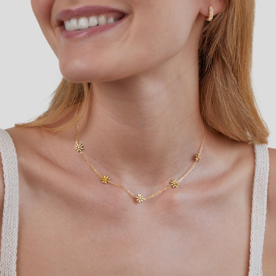 Flower Power 18K Gold Necklace, worn on a smiling model with a white knit top