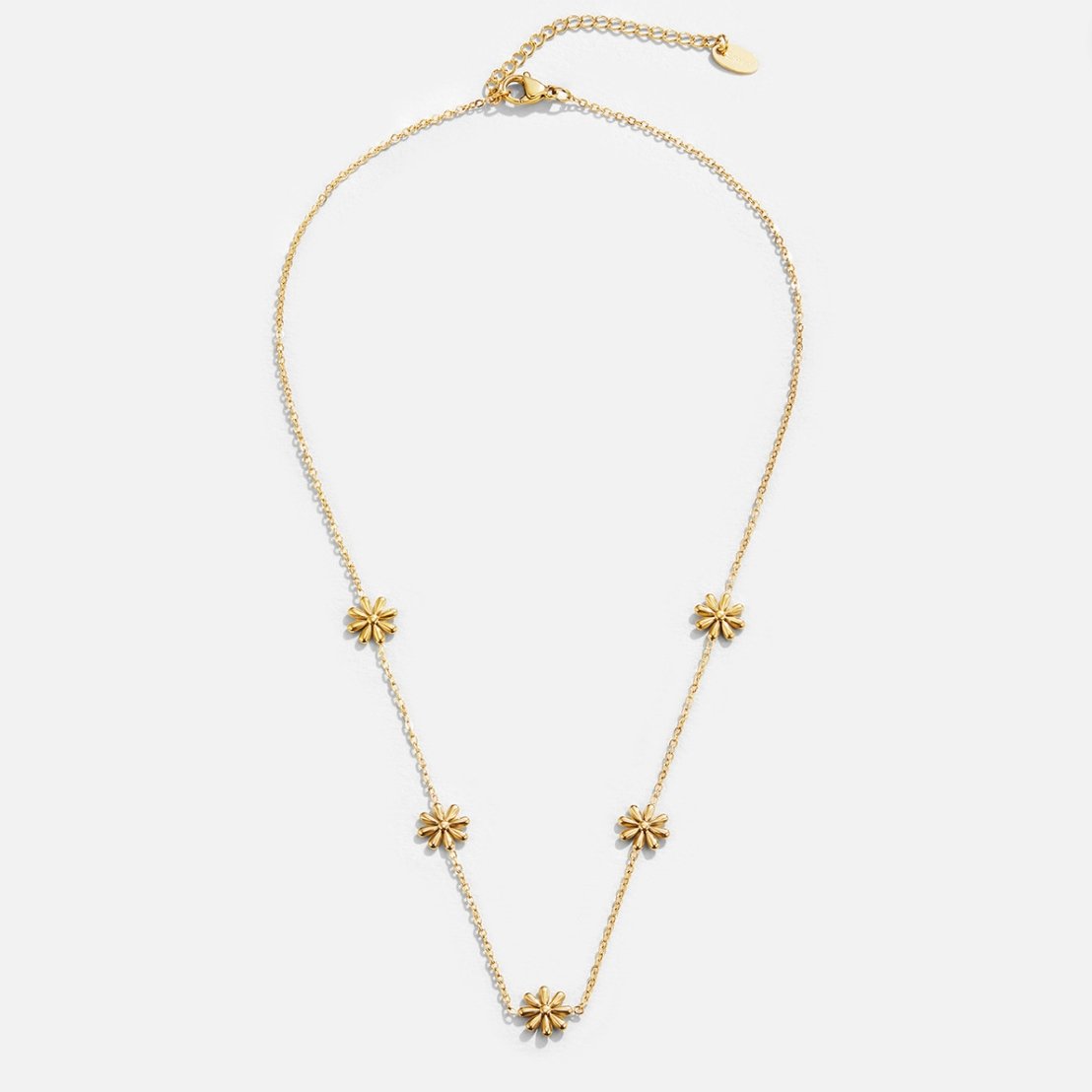 Flower Power 18K Gold Necklace, flat lay of a fine gold chain with five small flower motifs