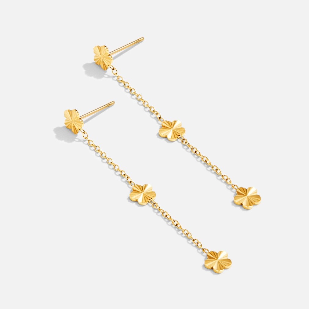 Flower Power Petal Drop Earrings, pair of gold flower-shaped drop earrings on a plain background