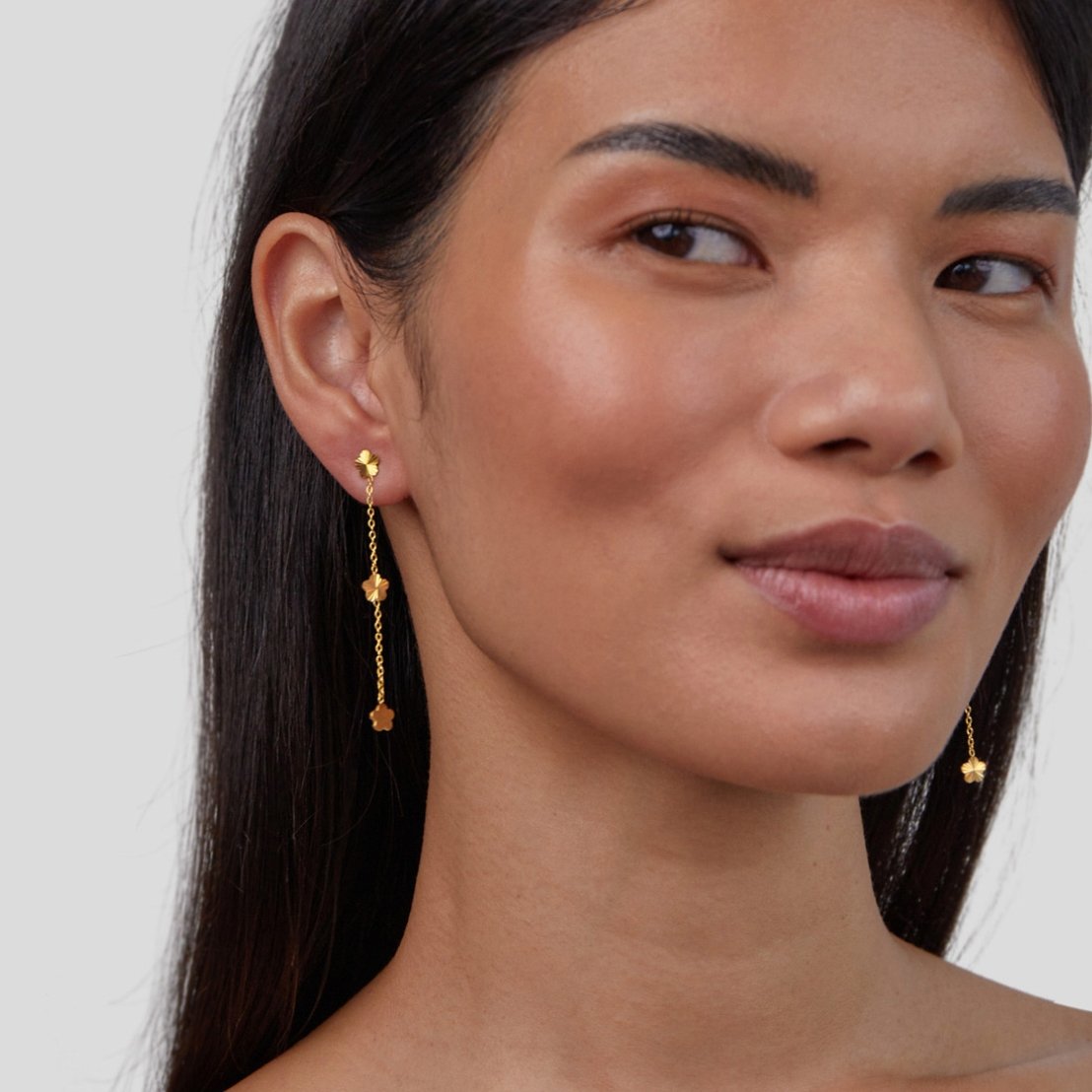 Flower Power Petal Drop Earrings, worn on a model's ear, long gold chain with flower charms