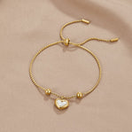Forever Love Heart Bracelet, laid flat on beige satin, heart charm with white centre